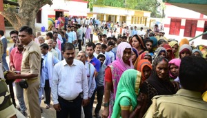 Voters at Model Government Primary School polling station at Randhawa in Phulpur constituency had to wait to cast their votes after two electronic voting machines (EVMs) in two booths developed glitches.(HT PHOTO)