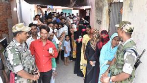 Voters wait in a queue holding their ID cards to cast their vote during the sixth phase of Lok Sabha elections in Dhanbad(ANI)