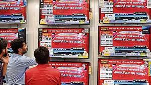 People watch exit poll predictions by various news channels in an electronics shop, at Laxmi Nagar, in New Delhi(HTPhotos)