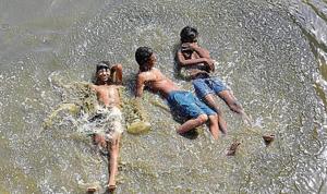 Children cool themselves off in the Yamuna on Wednesday. According to IMD, the heatwave will continue for at least a week with no respite in the form of pre-monsoon showers.(HT Photo/Virendra Singh) Children cool themselves off in the Yamuna on Wednesday. According to IMD, the heatwave will continue for at least a week with no respite in the form of pre-monsoon showers.(HT Photo/Virendra Singh)