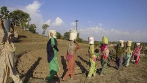 Villagers carry vessels containing drinking water from an almost dried-up well due to summer, at Padal village of Samba district in Jammu on June 2, 2019.(PTI) Villagers carry vessels containing drinking water from an almost dried-up well due to summer, at Padal village of Samba district in Jammu on June 2, 2019.(PTI)