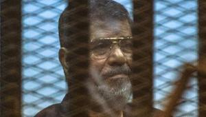 Egypt's deposed Islamist president Mohammed Morsi sits behind the defendant's cage as the judge reads out his verdict sentencing him and more than 100 other defendants to death at the police academy in Cairo.((AFP Photo)) Egypt's deposed Islamist president Mohammed Morsi sits behind the defendant's cage as the judge reads out his verdict sentencing him and more than 100 other defendants to death at the police academy in Cairo.((AFP Photo))