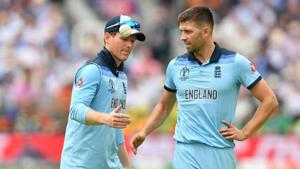 England's captain Eoin Morgan (L) speaks with teammate England's Mark Wood(AFP)