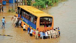 Police personnel push an empty school bus, one of the three vehicles that stalled on a waterlogged road at Subhash Chowk, on Thursday. (Right) Bikers wade their way past cars and buses on a flooded Gurugram-Sohna Road.(Parveen Kumar /HT photos) Police personnel push an empty school bus, one of the three vehicles that stalled on a waterlogged road at Subhash Chowk, on Thursday. (Right) Bikers wade their way past cars and buses on a flooded Gurugram-Sohna Road.(Parveen Kumar /HT photos)