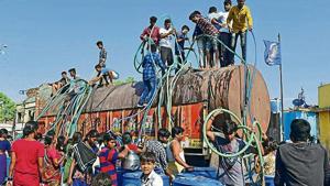 Villagers from Bhim Nagar in Wadwani tehsil of Beed jump onto the tankers within seconds it enters into the village. 24000 liter stock is emptied in their small tanks and pots in just 10 to 15 minutes(Vijayanand/HTPhotos) Villagers from Bhim Nagar in Wadwani tehsil of Beed jump onto the tankers within seconds it enters into the village. 24000 liter stock is emptied in their small tanks and pots in just 10 to 15 minutes(Vijayanand/HTPhotos)