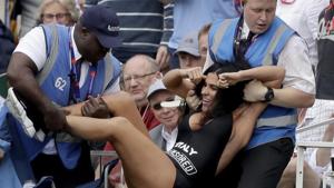 A pitch invader is carried away by stewards after they prevented her getting on the pitch.(AP) A pitch invader is carried away by stewards after they prevented her getting on the pitch.(AP)