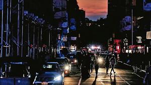 People walk along a dark street near Times Square in Manhattan, New York on Sunday.(Reuters Photo) People walk along a dark street near Times Square in Manhattan, New York on Sunday.(Reuters Photo)