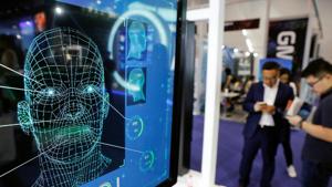 Visitors check their phones behind the screen advertising facial recognition software during Global Mobile Internet Conference (at the National Convention, Beijing, China, 2018(REUTERS) Visitors check their phones behind the screen advertising facial recognition software during Global Mobile Internet Conference (at the National Convention, Beijing, China, 2018(REUTERS)
