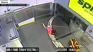 Video shows him crawling over bags, trying to avoid being pulled through a large screening machine that resembles a darkened cave above the conveyor belt.(Screengrab) Video shows him crawling over bags, trying to avoid being pulled through a large screening machine that resembles a darkened cave above the conveyor belt.(Screengrab)