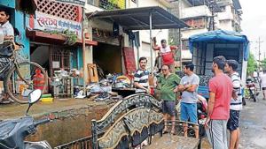 After Saturday’s deluge, life is yet to return to normal for people in Badlapur. Here, residents of Rameshwadi stand outside their homes with whatever items they could salvage.(HT FILE)