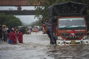 Mumbai, India - Aug. 4, 2019: People walk from flooded road as there is water logging due to heavy rain on LBS Road near Sion station in Mumbai, India, on Sunday, August 4, 2019. (Photo by Pratik Chorge/Hindustan Times)(Pratik Chorge/HT Photo)