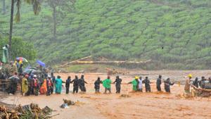 Rescuers help people to cross a flooded area after a landslide caused by torrential monsoon rains in Meppadi in Wayanad district in the southern Indian state of Kerala, India, August 9, 2019.(REUTERS) Rescuers help people to cross a flooded area after a landslide caused by torrential monsoon rains in Meppadi in Wayanad district in the southern Indian state of Kerala, India, August 9, 2019.(REUTERS)
