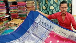 A shopkeeper in Varanasi displays a banarasi saree.(HT Photo) A shopkeeper in Varanasi displays a banarasi saree.(HT Photo)