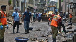 Mumbai corporation workers cleaning the street after water level recede in Sangli.(Uday Deolekar/ Hindustan Times) Mumbai corporation workers cleaning the street after water level recede in Sangli.(Uday Deolekar/ Hindustan Times)