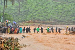 Rescuers help people to cross a flooded area after a landslide caused by torrential monsoon rains in Meppadi in Wayanad district in Kerala, August 9, 2019.(Reuters file photo) Rescuers help people to cross a flooded area after a landslide caused by torrential monsoon rains in Meppadi in Wayanad district in Kerala, August 9, 2019.(Reuters file photo)