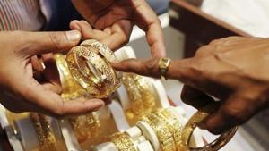 An employee shows gold bangles to a customer at a jewellery showroom. On Monday, gold prices stood at Rs 38,449 per 10 gram, while silver was at at Rs 46,880 per kilogram.(Reuters) An employee shows gold bangles to a customer at a jewellery showroom. On Monday, gold prices stood at Rs 38,449 per 10 gram, while silver was at at Rs 46,880 per kilogram.(Reuters)