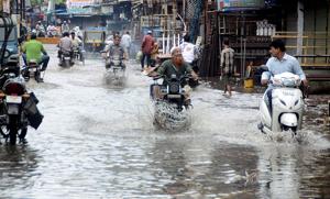 Commuters passing through the waterlogged street after heavy rain in Bhopal on Sunday.(Photo: ANI) Commuters passing through the waterlogged street after heavy rain in Bhopal on Sunday.(Photo: ANI)