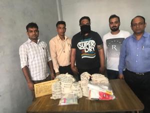 The accused(face covered) with the seized contraband(HT PHOTO) The accused(face covered) with the seized contraband(HT PHOTO)