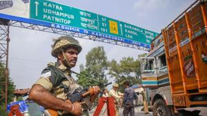 A BSF jawan guards as Jammu and Kashmir Police personnel check the vehicles on the Jammu-Srinagar highway after a truck was seized with arms and ammunition, in Kathua.(PTI) A BSF jawan guards as Jammu and Kashmir Police personnel check the vehicles on the Jammu-Srinagar highway after a truck was seized with arms and ammunition, in Kathua.(PTI)