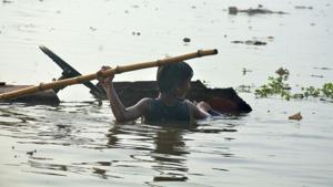 A child wades through flood water in a low-lying area of Prayagraj, Uttar Pradesh.(HT Photo) A child wades through flood water in a low-lying area of Prayagraj, Uttar Pradesh.(HT Photo)