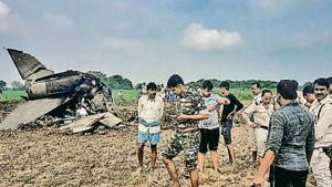 Policemen and locals gather at the site where MiG-21 trainer jet crashed near the Gwalior airbase on Wednesday.(PTI) Policemen and locals gather at the site where MiG-21 trainer jet crashed near the Gwalior airbase on Wednesday.(PTI)