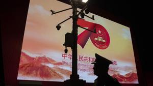 In this Saturday, Sept. 28, 2019, photo, a security officer passes by surveillance cameras near a display for the 70th anniversary of the Founding of the People's Republic of China in Beijing. Patriotic banners, elaborate flower displays and tightened security are all on tap as the Chinese capital prepares to mark the 70th anniversary of Communist Party rule on Tuesday, Oct. 1, 2019.(AP) In this Saturday, Sept. 28, 2019, photo, a security officer passes by surveillance cameras near a display for the 70th anniversary of the Founding of the People's Republic of China in Beijing. Patriotic banners, elaborate flower displays and tightened security are all on tap as the Chinese capital prepares to mark the 70th anniversary of Communist Party rule on Tuesday, Oct. 1, 2019.(AP)