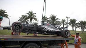 Track crew lifting Haas driver Romain Grosjean’s car at the Malaysian Formula One Grand Prix.(AP)