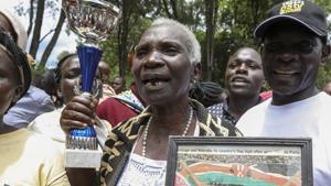 Eliud Kipchoge's mother Janet Rotich holds a photograph of her son as she celebrates(AP) Eliud Kipchoge's mother Janet Rotich holds a photograph of her son as she celebrates(AP)