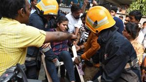 Firefighters with a woman rescued from a commercial building in which fire broke out , Andheri in Mumbai, on Monday, October 14, 2019.(HT PHOTO) Firefighters with a woman rescued from a commercial building in which fire broke out , Andheri in Mumbai, on Monday, October 14, 2019.(HT PHOTO)