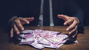 Businessman taking pile of money, Indian Rupee banknotes, on his desk in a dark office - corruption concept(Getty Images/iStockphoto) Businessman taking pile of money, Indian Rupee banknotes, on his desk in a dark office - corruption concept(Getty Images/iStockphoto)