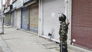 A security person stands guard during shutdown in Srinagar.(PTI Photo) A security person stands guard during shutdown in Srinagar.(PTI Photo)