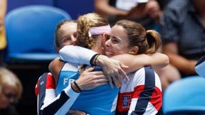 France's Kristina Mladenovic is hugged by teammates Alize Cornet, right, and Fiona Ferro after winning her match against Australia's Ash Barty during their Fed Cup final in Perth.(AP) France's Kristina Mladenovic is hugged by teammates Alize Cornet, right, and Fiona Ferro after winning her match against Australia's Ash Barty during their Fed Cup final in Perth.(AP)