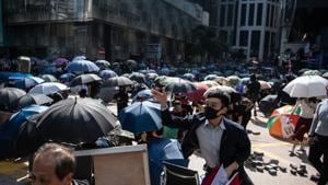 A demonstrator throws a brick on Pedder Street during a lunchtime protest in the Central district of Hong Kong.(Bloomberg photo) A demonstrator throws a brick on Pedder Street during a lunchtime protest in the Central district of Hong Kong.(Bloomberg photo)
