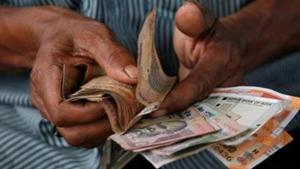 An attendant at a fuel station arranges rupee notes(REUTERS File) An attendant at a fuel station arranges rupee notes(REUTERS File)