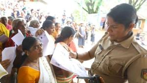 A police officer checking documents of women devotees to know their age. Woman in yellow sari was later forced to retreat since she was 42.(Vivek R Nair/HT Photo) A police officer checking documents of women devotees to know their age. Woman in yellow sari was later forced to retreat since she was 42.(Vivek R Nair/HT Photo)