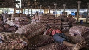 A worker sleeps on sacks of onions at the Vashi Agricultural Produce Market Committee (APMC) wholesale market in Mumbai.(Bloomberg) A worker sleeps on sacks of onions at the Vashi Agricultural Produce Market Committee (APMC) wholesale market in Mumbai.(Bloomberg)