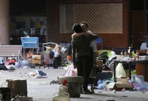A protester hugs a social worker inside the campus of Hong Kong Polytechnic University in Hong Kong.(AP) A protester hugs a social worker inside the campus of Hong Kong Polytechnic University in Hong Kong.(AP)
