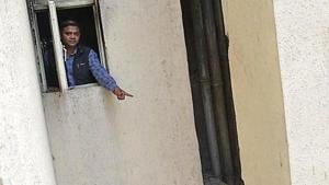 A man points to the beam on to which Rahul Singh had jumped to save himself from the fire on Tuesday morning.(Sakib Ali/ht photo) A man points to the beam on to which Rahul Singh had jumped to save himself from the fire on Tuesday morning.(Sakib Ali/ht photo)