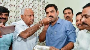 Karnataka Chief Minister BS Yediyurappa offers sweets to his younger son BY Vijayendra after BJP won in 12 out of 15 assembly constituencies in the bypolls in Karnataka.(PTI) Karnataka Chief Minister BS Yediyurappa offers sweets to his younger son BY Vijayendra after BJP won in 12 out of 15 assembly constituencies in the bypolls in Karnataka.(PTI)