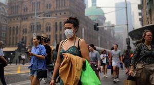 Pedestrians are seen wearing masks as smoke haze from bushfires in New South Wales blankets the CBD in Sydney, Australia.(REUTERS) Pedestrians are seen wearing masks as smoke haze from bushfires in New South Wales blankets the CBD in Sydney, Australia.(REUTERS)