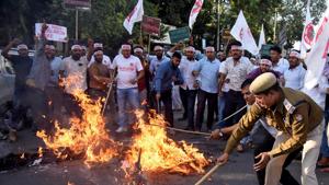 A police officer removes burning effigies that were set on fire by Activists from the All Assam Students Union (AASU) during a protest against the Citizenship Amendment Bill.(File photo: Reuters) A police officer removes burning effigies that were set on fire by Activists from the All Assam Students Union (AASU) during a protest against the Citizenship Amendment Bill.(File photo: Reuters)