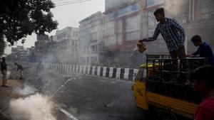 Police clear road blocks as a man tries to douse a fire set by protesters in Guwahati, Assam, on Thursday.(AP Photo) Police clear road blocks as a man tries to douse a fire set by protesters in Guwahati, Assam, on Thursday.(AP Photo)