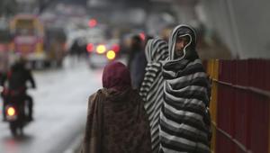 Pedestrians cover themselves as they take shelter under a flyover bridge from rain in Jammu on Friday.(AP Photo) Pedestrians cover themselves as they take shelter under a flyover bridge from rain in Jammu on Friday.(AP Photo)