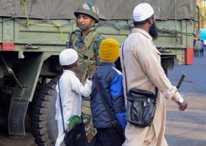 A man along with children walk past him a security personnel during relaxation of curfew, in Dibrugarh, Friday, Dec. 13, 2019. Curfew was relaxed for a few hours on Saturday and Sunday as well.(PTI) A man along with children walk past him a security personnel during relaxation of curfew, in Dibrugarh, Friday, Dec. 13, 2019. Curfew was relaxed for a few hours on Saturday and Sunday as well.(PTI)
