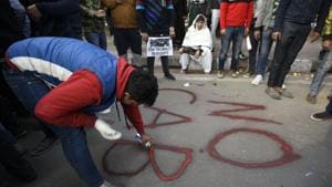 A protester paints graffiti on a road, during a protest by students and local residents against the Citizenship Amandment Act (CAA) and National Register of Citizens (NRC), at Jamia Millia Islamia University.(Burhaan Kinu/HT PHOTO) A protester paints graffiti on a road, during a protest by students and local residents against the Citizenship Amandment Act (CAA) and National Register of Citizens (NRC), at Jamia Millia Islamia University.(Burhaan Kinu/HT PHOTO)