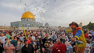 A clown entertains people as Palestinian Muslims perform the morning Eid al-Fitr prayer near the Dome of Rock mosque at the Al-Aqsa Mosque compound, Islam's third most holy site, in the Old City of Jerusalem on June 5, 2019(AFP) A clown entertains people as Palestinian Muslims perform the morning Eid al-Fitr prayer near the Dome of Rock mosque at the Al-Aqsa Mosque compound, Islam's third most holy site, in the Old City of Jerusalem on June 5, 2019(AFP)