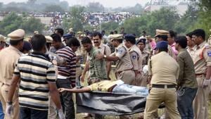 Police personnel carries the body from the spot where accused in the rape and murder of the woman veterinarian were killed in an encounter, in Hyderabad.(ANI Photo) Police personnel carries the body from the spot where accused in the rape and murder of the woman veterinarian were killed in an encounter, in Hyderabad.(ANI Photo)