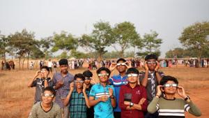 Boys use special glasses to watch the annular solar eclipse in Cheruvathur town in Kerala.(Reuters Photo)