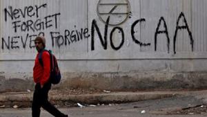 A man walks past a graffiti during a protest against a new citizenship law.(Reuters file photo) A man walks past a graffiti during a protest against a new citizenship law.(Reuters file photo)