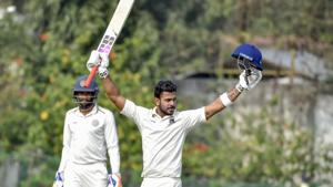 Nadia: Bengal batsman Manoj Tiwary (C) raises his bat after scoring 300.(PTI)